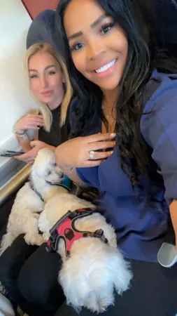 Two women cuddling their small dogs.